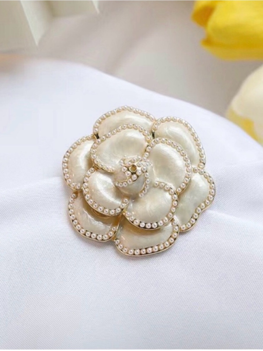 white gold camellia flower brooch featuring enamel petals bordered faux pearls